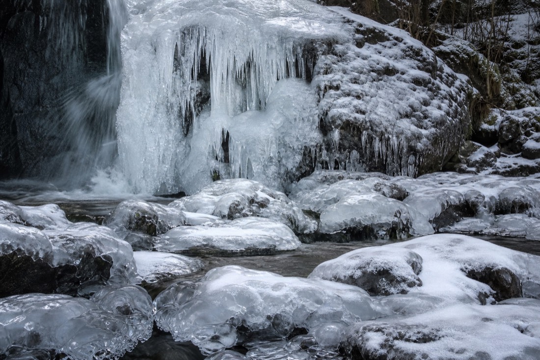 A frozen waterfall and iced rock in a Lapland stream bed