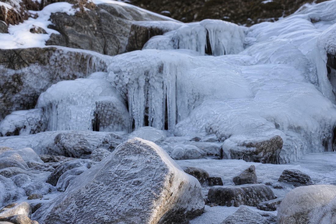 A frozen waterfall and iced rock in a Lapland stream bed